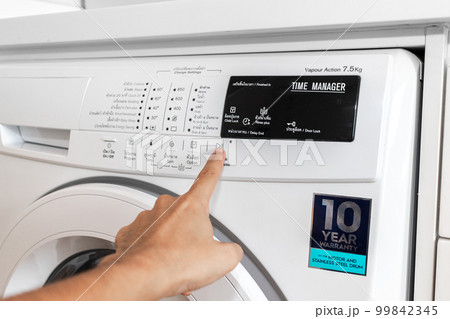 Modern white front-loading washing machine with control buttons Modern white front-loading washing machine with control buttons 99842345