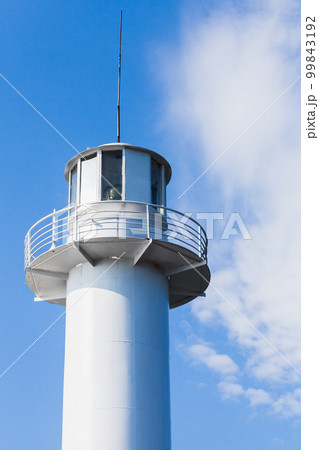 White lighthouse tower is under blue sky on a daytime, port of Varna 99843192