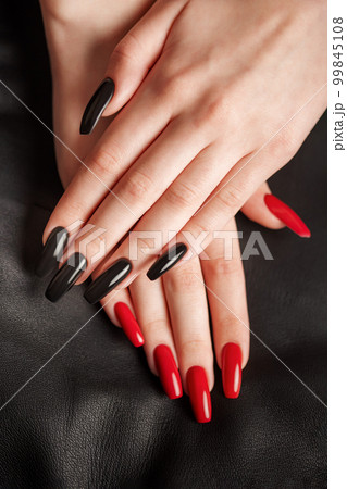 Hands of a young girl with black and red manicure on nails 99845108