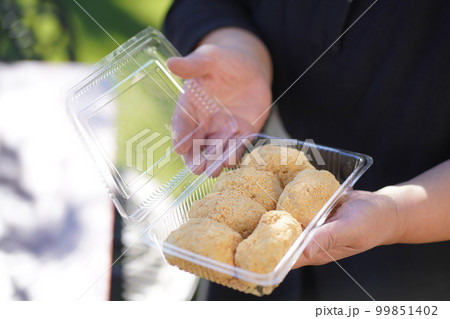 手作りのきなこおはぎを持つ女性 99851402