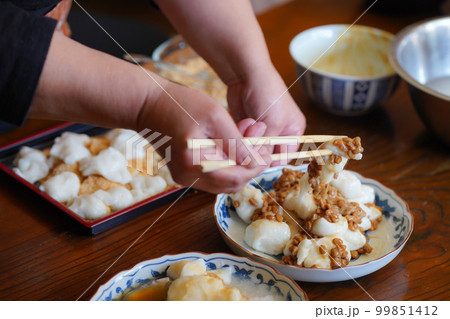 つきたてのお餅に食材を絡める女性 つきたてのお餅に食材を絡める女性 99851412