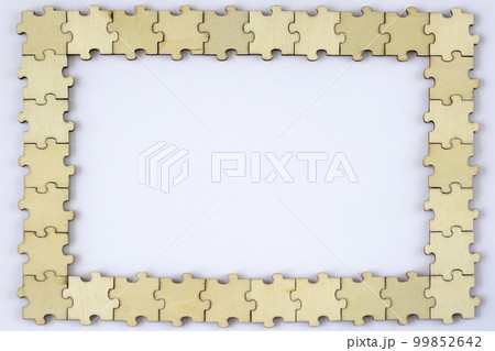 Frame of wooden puzzles on a white background. Blank mock up for design or lettering. 99852642