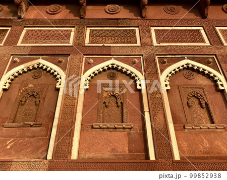 The famous red fort in the city of Agra, India. Tourists visit a popular tourist attraction. 99852938