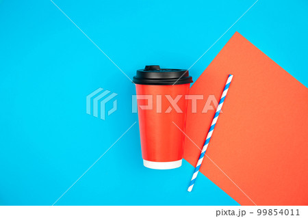 Paper cup and paper straw for drinks on a blue background, flat lay. 99854011