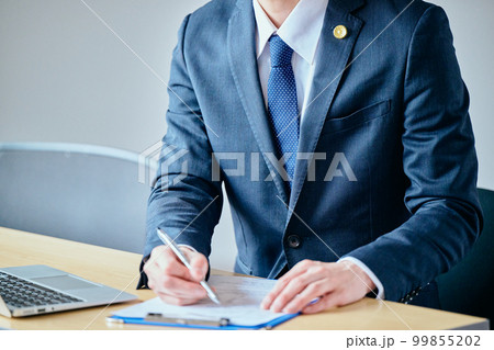 法律相談で依頼者から聞き取りをする若い弁護士 99855202