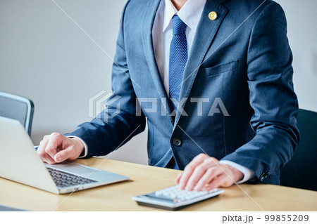電卓で計算をする若い弁護士 99855209