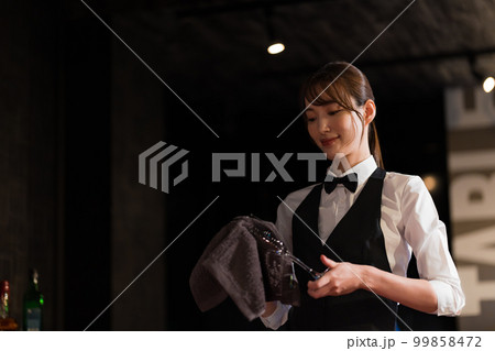 グラスを拭く女性バーテンダー グラスを拭く女性バーテンダー 99858472