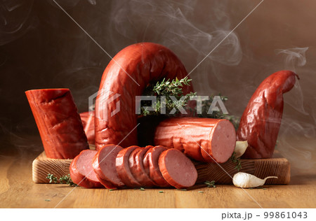 Smoked sausage with thyme and garlic on a wooden table. Smoked sausage with thyme and garlic on a wooden table. 99861043