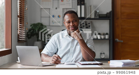 American African Businessman research and analysis with financial graph at office. Strategy, chart, finance report concept 99861948