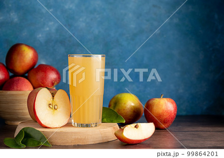 Apple cider cocktail, juice drink with fresh red apples, blue vibrant background, copy space Apple cider cocktail, juice drink with fresh red apples, blue vibrant background, copy space 99864201