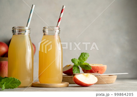 Apple juice glass bottles, with fresh red apples, wooden background. 99864205