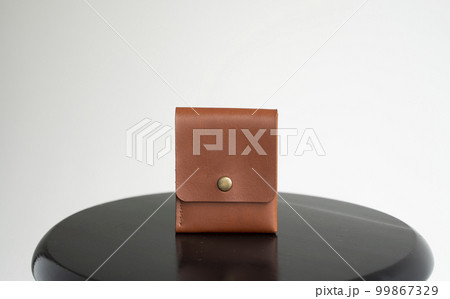 Orange men's business leather card holder on a black chair with a white background. Men's accessories. Orange men's business leather card holder on a black chair with a white background. Men's accessories. 99867329