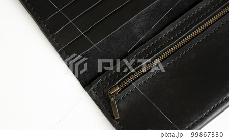 Details of open handmade brown man's genuine leather wallet with zipper on a button for banknotes and credit cards isolated on white background. Details of open handmade brown man's genuine leather wallet with zipper on a button for banknotes and credit cards isolated on white background. 99867330