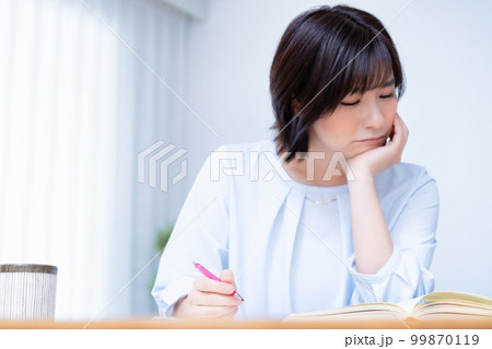 リビングで勉強中に悩む女性 リビングで勉強中に悩む女性 99870119