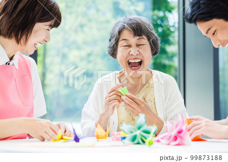折り紙を折るシニア女性と介護士　撮影協力「LINK FOREST」 99873188