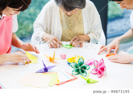 折り紙を折るシニア女性と介護士　撮影協力「LINK FOREST」 99873195