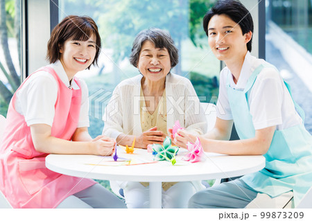 折り紙を折るシニア女性と介護士　撮影協力「LINK FOREST」 99873209