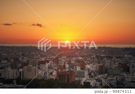 松山城から望む愛媛県松山市の市街地と瀬戸内海に沈む夕日 99874311