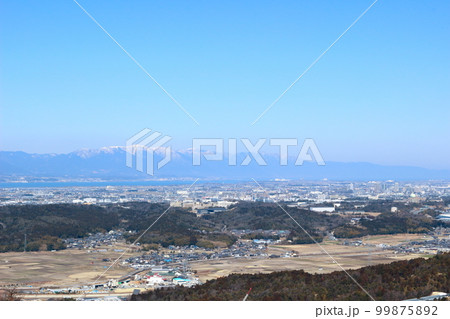 湖南アルプス堂山の登山道から眺めた雪をかぶった琵琶湖対岸の比良山地 99875892