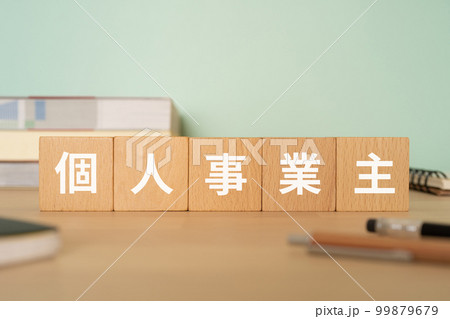 個人事業主と書かれたブロックが置かれたデスク 99879679