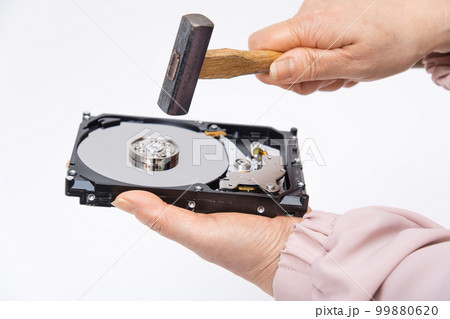 【HDDをハンマーで破壊する女性】 【HDDをハンマーで破壊する女性】 99880620