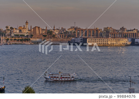 Luxor ,Egypt sunset shot from west bank showing Nile river with cruise ships , Feluccas and Winter palace hotel  in east bank 99884076