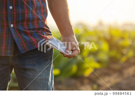 Empty budget, Lose profit, Fail, or unsuccessful in business concept. Asian farmer is standing in the field of tobacco tree and show trouser pocket. Empty budget, Lose profit, Fail, or unsuccessful in business concept. Asian farmer is standing in the field of tobacco tree and show trouser pocket. 99884561