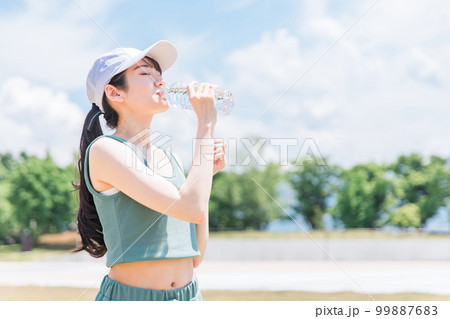 公園で水・ミネラルウォーターを飲む女性(水分補給・運動・ワークアウト・ランニング・ウォーキング) 公園で水・ミネラルウォーターを飲む女性(水分補給・運動・ワークアウト・ランニング・ウォーキング) 99887683
