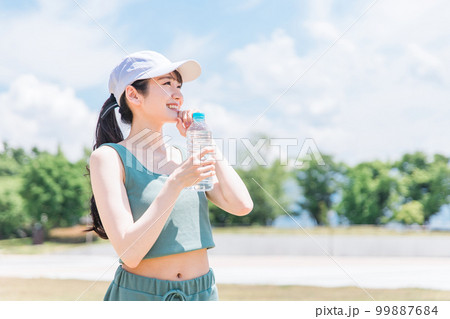 公園で水・ミネラルウォーターを飲む女性(水分補給・運動・ワークアウト・ランニング・ウォーキング) 公園で水・ミネラルウォーターを飲む女性(水分補給・運動・ワークアウト・ランニング・ウォーキング) 99887684