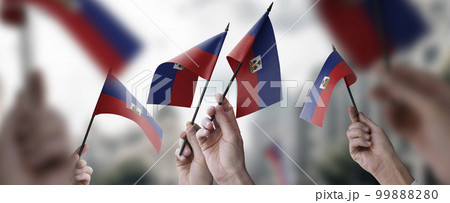 A group of people holding small flags of the Haiti in their hands 99888280
