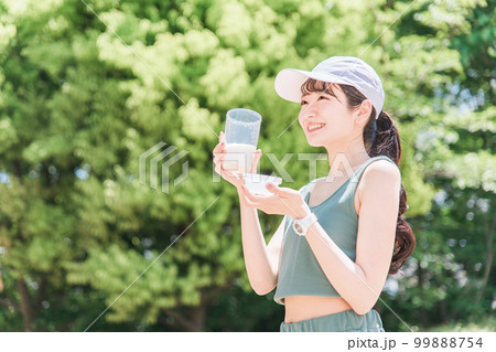 公園でトレーニングしながらプロテインを飲む女性 99888754