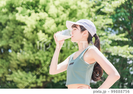 公園でトレーニングしながらプロテインを飲む女性 公園でトレーニングしながらプロテインを飲む女性 99888756