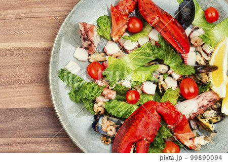 Mix of salad with seafood on plate, top view Mix of salad with seafood on plate, top view 99890094