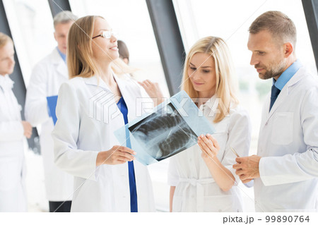 Group of doctors looking at x-ray Group of doctors looking at x-ray 99890764