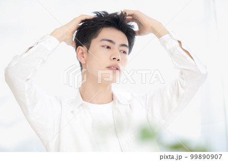 美容系のヘアセットやシャンプーなど髪の毛のイメージに使えそうな男性のポーズ 美容系のヘアセットやシャンプーなど髪の毛のイメージに使えそうな男性のポーズ 99890907