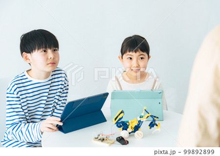 プログラミング教室でロボットの操作を学ぶ女の子と男の子 99892899
