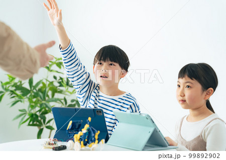 プログラミング教室でロボットの操作を学ぶ女の子と男の子 プログラミング教室でロボットの操作を学ぶ女の子と男の子 99892902