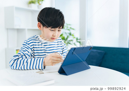 タブレットを見ながら勉強する男の子 99892924