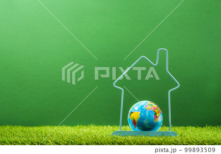 Earth Day. Earth globe in house frame in green background. Environment day, save clean planet, ecology concept. Renewable energy efficient technologies. Climate change and global warming. 99893509