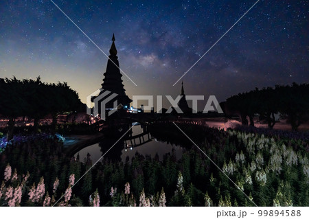 Night sky time lapse of moving Milky Way and stars under moon light at Phra Mahathat monuments on Doi Inthanon 99894588