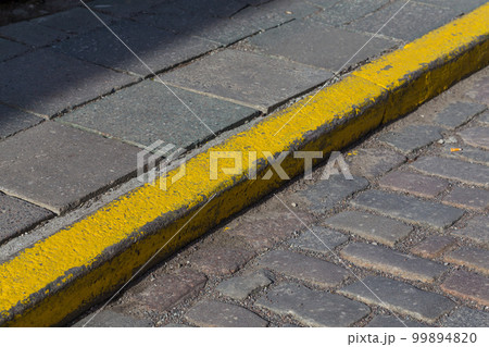 Yellow curb stone border Yellow curb stone border 99894820