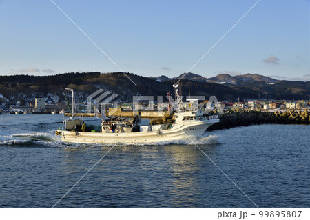 早春の北海道八雲町落部漁港から出漁するホタテ漁船の朝の風景を撮影 99895807