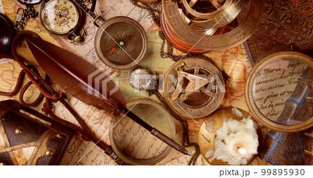 Vintage style travel and adventure. Vintage old compass and other vintage items on the table. 99895930