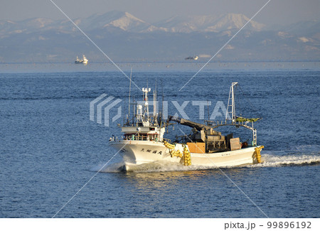 早春の北海道八雲町落部漁港に帰港するホタテ漁船の朝の風景を撮影 99896192