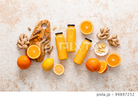 Smoothie. Healthy fresh raw detox citrus smoothie with orange, lemon, ginger and turmeric in a glass bottles on a table. Healthy diet vegan food full of antioxidants Smoothie. Healthy fresh raw detox citrus smoothie with orange, lemon, ginger and turmeric in a glass bottles on a table. Healthy diet vegan food full of antioxidants 99897252