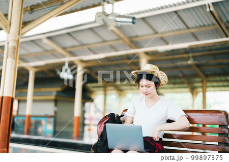 summer, relax, vacation, travel, portrait of beautiful Asian girl using the computer laptop at the train station while waiting for their travel time summer, relax, vacation, travel, portrait of beautiful Asian girl using the computer laptop at the train station while waiting for their travel time 99897375