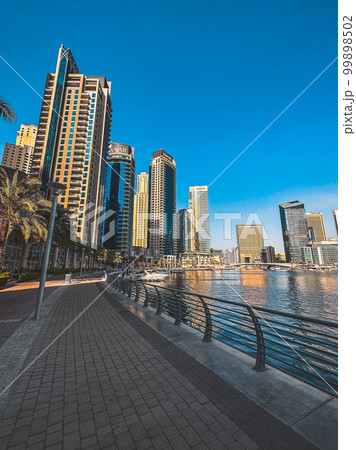 Dubai Marina, harbour, cruise boat and canal promenade view at sunset, in Dubai, United Arab Dubai Marina, harbour, cruise boat and canal promenade view at sunset, in Dubai, United Arab 99898502