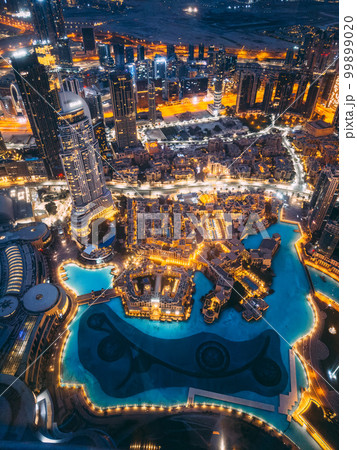 Aerial view of Downtown Dubai with roads, Dubai Mall and the fountain by night, from Burj Khalifa 99899020