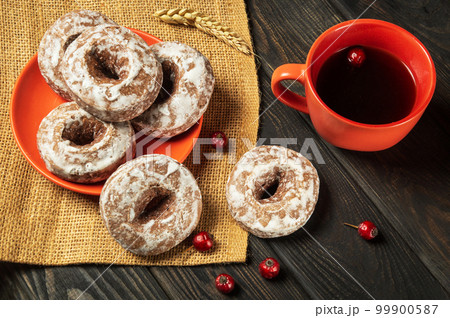 Homemade round gingerbread cookies with icing in a plate and hot rosehip tea. Idea for a delicious breakfast or dinner Homemade round gingerbread cookies with icing in a plate and hot rosehip tea. Idea for a delicious breakfast or dinner 99900587