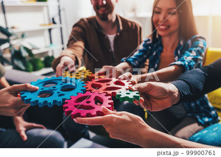Teamwork of business people work together and combine pieces of gears 99900761